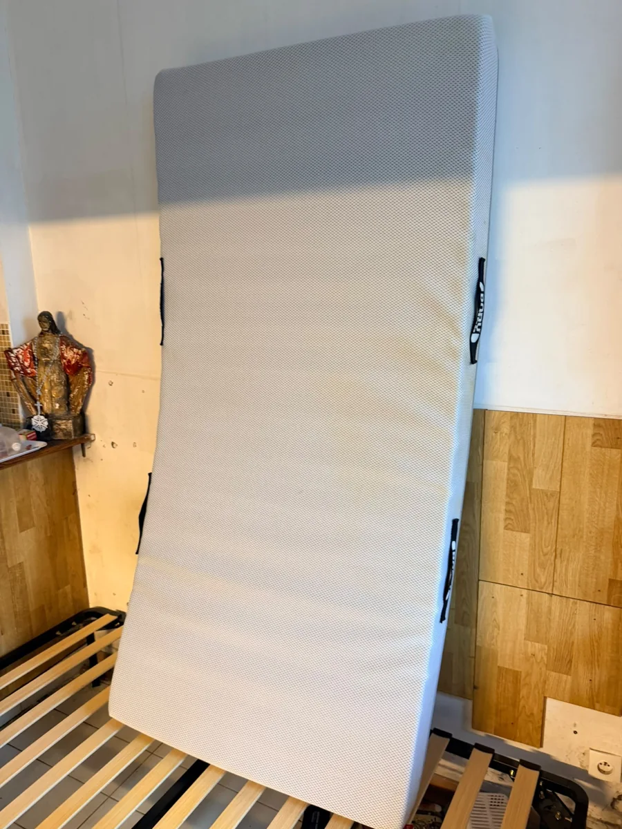 Matelas relevé laissant visibles les lattes du sommier et le cadre du lit